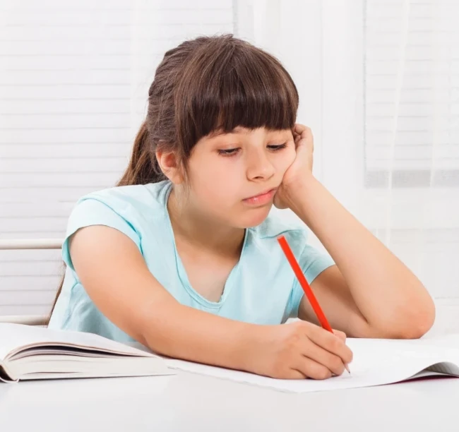 Criança pensativa com dificuldades nos estudos